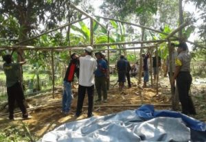 Bhabinkamtibmas Desa Karangmulya, Bripka Karyono saat bergotong royong bersama aparatur desa dan warga setempat membangun rumah semantara bagi kealuarga Bapak Sanan, Selasa (14/01) siang.