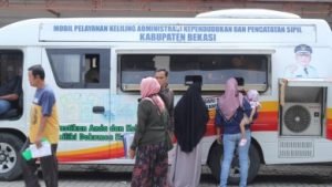 Sejumlah warga saat mendapatkan pelayanan cetak ulang KK, Akte dan e-KTP dengan menggunakan mobil pelayanan adminduk Dinas Kependudukan dan Catatan Sipil Kabupaten Bekasi.