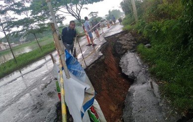 Kondisi ruas jalan Inspeksi Kalimalang di Kp. Cilampayan, RT 11/07 Desa Pasir Tanjung, Kecamatan Cikarang Pusat yang amblas sedalam 2 meter, Kamis (27/02).
