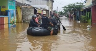 Proses evakuasi warga oleh anggota TNI di wilayah Kecamatan Setu yang terendam banjir, Selasa (02/03) pagi.