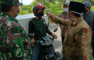 Kegiatan pengecekan suhu, pembagian masker dan pembatasan penumpang kendaraan bermotor oleh aparatur Desa Karangmekar, Kecamatan Kedungwaringin