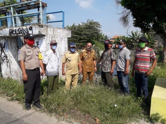 Camat Muaragembong Lukman Hakim bersama unsur Muspika dan aparatur Desa Pantai harapan Jaya saat meninjau kondisi Pintu Air Kali Cikarang yang tersumbat tumpukan sampah, Jum'at (17/04).