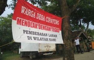 Spanduk penolakan pembebasan lahan di Jl. Kp. Buni Herang - Kp. Ciranggon yang dipasang warga Desa Cipayung, Kecamatan Cikarang Timur