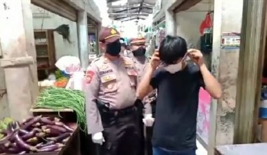 Pembagian maske kain secara gratis oleh Muspika Cikarang Pusat di Pasar Tegal Danas, Selasa (07/04).