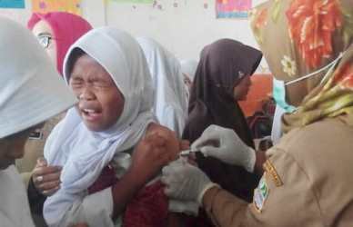 Salah seorang siswi SD Negeri 02 Tambun Utara saat disuntik imunisasi difteri pada Selasa (09/01) pagi.