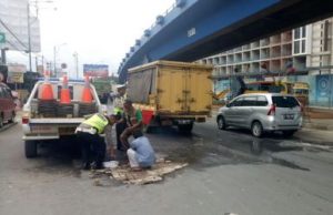 Anggota Dikyasa Satuan Lalu Lintas Polres Metro Bekasi bersama tukang ojek dan warga sekitar bahu membahu menambal jalan berlubang di ruas Jl. Raya Cikarang – Cibarusah yang berada tepat dibawah fly over Tol Cikarang Barat, Selasa (09/01) pagi.