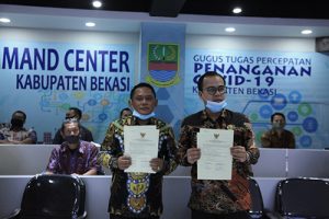 Bupati Bekasi Eka Supria Atmaja didampingi oleh Ketua DPRD Kabupaten Bekasi Aria Dwi Nugraha saat menghadiri Penyerahan Laporan Hasil Pemeriksaan (LPH) secara virtual di Ruang Command Center Gedung Diskominfo Kabupaten Bekasi, Kamis (25/06). | Foto: Humas Pemkab Bekasi