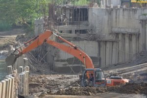 Satu unit alat berat dikerahkan untuk mencabut pilar-pilar beton (sheetpile) yang tersusun di tengah sungai cibeet di Kawasan tempat wisata air Dwi Sari Waterpark, Kamis (25/06).