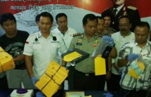 Polisi saat menunjukan barang bukti yang berhasil diamankan Satgas Saber Pungli berupa 75 buah sertifikat, 1 buah handphone, uang tunai Rp. 20 juta dan 1 buah dekoder CCTV, Jum'at (16/03) sore.