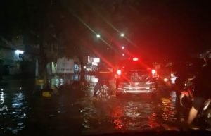 Tampak para pengendara motor sedang berusaha melintasi jalan raya di pusat pertokoan Jababeka II, Desa Mekarmukti, Kecamatan Cikarang Utara akibat air Sungai Cilembahabang meluap, tadi malam (12/12).