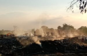 Petugas Damkar saat melakukan proses pendinginan di lokasi tumpukan limbah plastik yang terbakar, Minggu (06/01) sore.