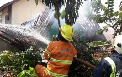 Petugas pemadam kebakaran Kabupaten Bekasi saat memadamkan rumah Ibu Dasih (49) yang terbakar, Rabu (23/10) pagi.