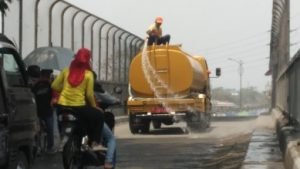 Proses penyiraman Jl. Raya Tegal Danas yang penuh debu, Jum'at (20/09).