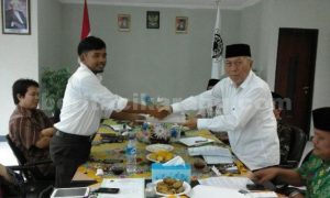 Ketua KPU Kabupaten Bekasi, Idham Holik saat menerima berkas rekomendasi hasil raker MUI secara simbolis yang diberikan oleh Sekretaris MUI Kabupaten Bekasi, H. Attoillah Mursyid, Kamis (31/03).