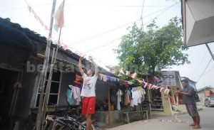 Sejumlah warga di Kp. Blok I RT 02/06 Desa Simpangan, Kecamatan Cikarang Utara tampak antusias memasang bendera merah putih plastik untuk menyambut HUT Kemerdekaan RI.