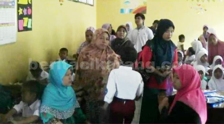 Orang tua murid kelas I SDN Sriamur 5 berebut bangku saat mengantarkan anaknya masuk di hari pertama sekolah, Senin (18/07).