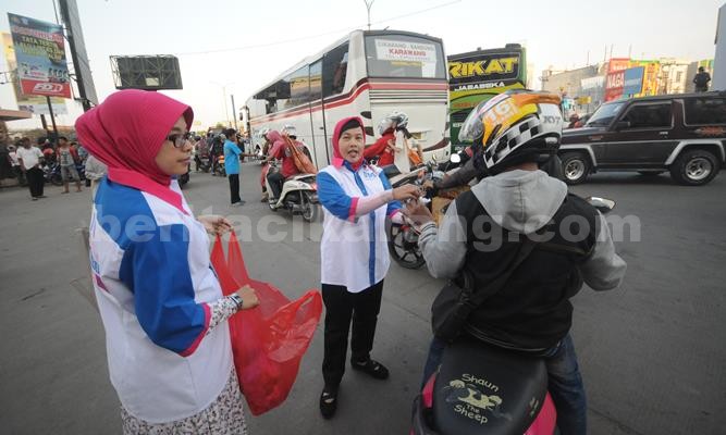 Nur’aeni, istri Daeng Muhammad saat turut serta di kegiatan pembagian takjil di perempatan SGC Cikarang, Sabtu (11/06) sore.