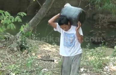 Salah seorang warga di Kp. Cihoe, Desa Ridogalih, Kecamatan Cibarusah saat mengambil air dari kali yang keruh dan berwarna kecoklatan untuk memenuhi kebutuhan sehari-hari seperti mencuci pakaian, piring dan mandi.