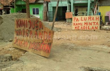 Aksi protes dengan menutup sementara proyek pembangunan tembok PT. Karang Pusaka dengan memasang papan bertuliskan tuntunan warga, Senin (09/10)