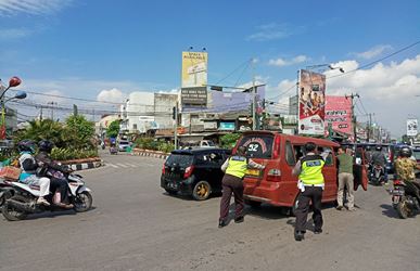 Anggota Polsek Cikarang Aiptu Junaidi dan Aiptu Supriyadi saat membantu mobil angkot K-52 jurusan Lemah Abang - Tegal Danas yang mogok di Jl. RE Martadinata, Desa Cikarang Kota Kecamatan Cikarang Utara, Kamis (21/06).