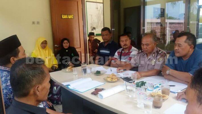 Kapolsubsektor Serang Baru, Aiptu I Made Juwita saat melakukan mediasi antara perwakilan warga dengan pihak yayasan Al-Ansori.