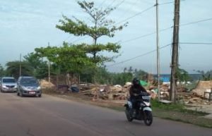 Pengendara sepeda motor saat melintas diantara puing-puing bangli pasca pembongkaran Satpol PP di Desa Pasir Tanjung Kecamatan Cikarang Pusat, Jum'at (16/11) pagi.
