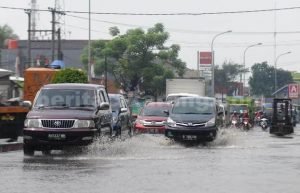 Sejumlah pengendara saat melintasi genangan air yang terdapat di Jl. Imam Bonjol, Kp. Rawa Palangan, Desa Telaga Murni, Kecamatan Cikarang Barat, Senin (08/08).
