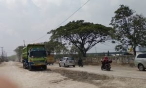 Sejumlah pengendara saat melintas di depan salah satu perusahaan pengolahan adukan semen di Jl. Inspeksi Kalimalang, Desa Cibatu, Kecamatan Cikarang Selatan