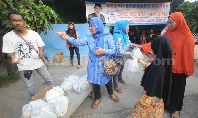 Warga perumahan Villa Bekasi Indah II, Desa Sumber Jaya, Kecamatan Tambun Selatan saat mengambil paket sembako di acara Bazar Paket Murah, Minggu (12/06) sore.