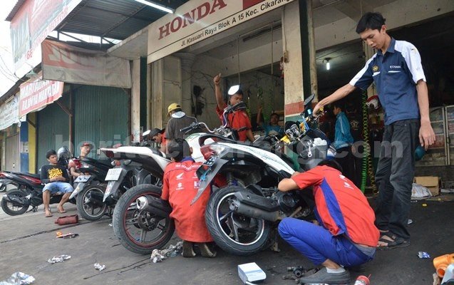 Salah seorang montir sepeda motor memperbaiki kendaraan bermotor di salah satu bengkel di Kawasan Pasimal, Cikarang Baru, Selasa (28/06)