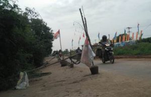 Seorang pengendara saat melintas di Jl. Raya Kali CB di Kp. Sasak Bakar, Desa Kertamukti Kecamatan Cibitung. Akibat jebolnya turap, separuh dari badan jalan tidak bisa digunakan dan nyaris ambrol.