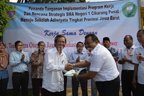Kepala Dinas Pendidikan Kabupaten Bekasi, MA. Supratman saat menyerahkan secara simbolis nota kesepahaman dengan lima perusahaan untuk meweujudkan sekolah Adiwiyata di SMAN 1 Cikarang Pusat.