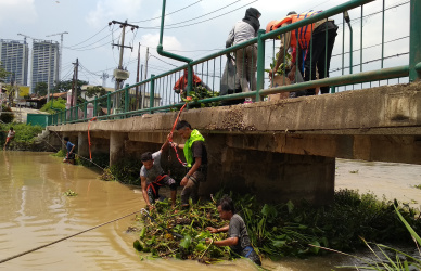 Sejumlah mahasiswa Pelita Bangsa saat membersihkan beberapa sampah dan eceng gondok yang hanyut setelah diurai petugas BPBD Kabupaten Bekasi menggunakan perahu karet, Sabtu (23/02).