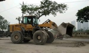 Pengerukan bekas ceceran beton tepat di depan PT Adhimix Indonesia Plant Deltamas, Jum'at (06/12) lalu. Sepakan berlalu, tumpukan material adukan beton yang telah mengering di badan jalan itu tak kunjung diangkut dan dibiarkan menumpuk di tepi Jalan Inspeksi Kalimalang.