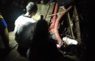 Salah seorang warga saat menggelar ritual dengan melakukan doa dan membakar dupa di sekitar lokasi tenggelamnya korban, Minggu (25/11) malam.