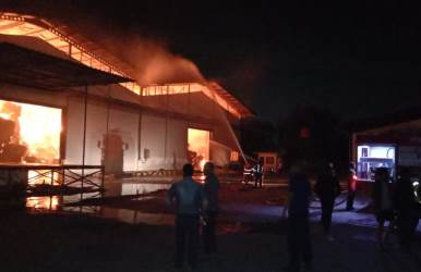 Petugas pemadam kebakaran saat berusahaa memadamkan kobaran api di gudang pabrik kertas yang terbakar sejak, Rabu (03/10) malam.