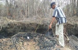 Ketua RT 02/02 Desa Ridomanah Kecamatan Cibarusah, Bapak Uman (53) saat menunjukan lokasi gundukan tanah yang mengeluarkan asap panas dan bau menyengat, Selasa (06/11) siang.