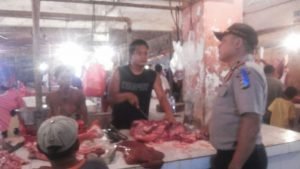 Anggota kepolisian sektor Babelan saat berdialog dengan pedagang daging sapi sekaligus melakukan pengecekan harga di Pasar Babelan, Selasa (05/07).