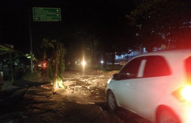 Pengguna jalan saat melintas di lokasi jalan rusak dan berlubang di Jl. Raya Tegal Danas yang ditanami pohon pisang, Rabu (06/02) malam.