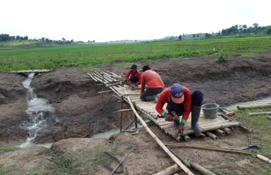 Progres pembangunan jembatan darurat yang kembali dibangun Kota Deltamas disisi barat jembatan darurat yang dikerjakan warga, Senin (25/02) siang.