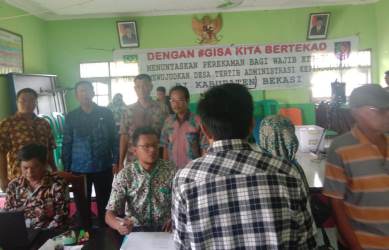 Kepala Dinas Kependudukan dan Catatan Sipil Kabupaten Bekasi, Ali Syahbana saat memantau langsung pelayanan ‘jemput bola’ perekaman e-KTP di Desa Karang Satria, Kamis (27/12).