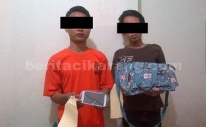 Tersangka JMR (kanan) dan AS (kiri) saat diamankan di Mapolsek Cikarang dengan barang bukti berupa satu buah tas, handphone dan dompet milik Anisa Supriyanti.