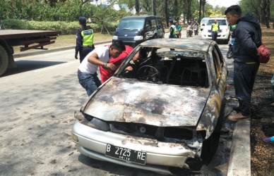 Petugas pemadam kebakaran dan pemilik kendaraan, Nemon Bin Sa'ad saat mengecek bagian dalam kendaraannya yang hangus terbakar, Jum'at (24/08) pagi.