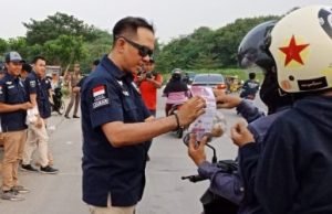 Kepala Lapas Cikarang, Kadek Anton Budiharta saat membagikan takjil dan menjelaskan tentang nilai-nilai Pancasila di selebaran yang dibagikan kepada pengendara motor di area Taman Sehati, Komplek Stadion Wibawamukti, Kamis (31/05).
