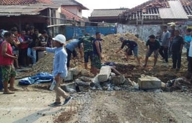 Proses evakuasi korban oleh warga di lokasi bekas galian pipa PDAM, Jl. Raya Cikarang – Cibarusah Kp. Kandang Roda, Desa Ciantra Kecamatan Cikarang Selatan, Jum’at (04/05) siang.