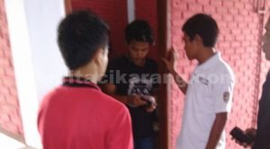 Anggota kepolisian saat memeriksa identitas penghuni salah satu kamar di sebuah losmen di Jl. Raya Pilar - Sukatani, Kamis (26/05) pagi.