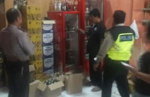 Petugas Kepolisian Sektor Tambun saat mengamankan barang bukti berupa puluhan botol miras jenis vodka iceland dari toko sembako milik TM yang berada di Jl. Raya Inspeksi Kalimalang, Tambun Selatan.