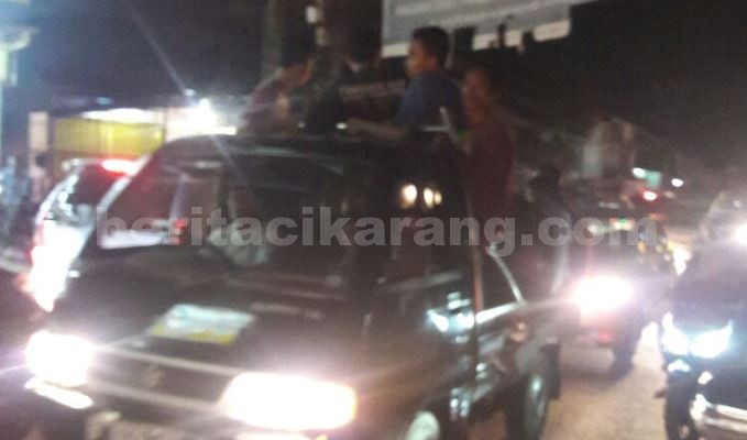 Sejumlah orang terlihat berada di mobil bak terbuka dalam pelaksanaan pawai takbiran Idul Fitri yang diselenggarakan oleh Forum Masyarakat Orang Bekasi saat melintas Jl. Raya Industri - Cikarang, Selasa (05/07) malam.