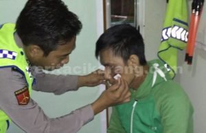 Bripka Samapta S, anggota Pospam 01 Indoporlen Polsek Tambun saat membersihkan luka di pipi korban dengan alkohol dan obat merah.