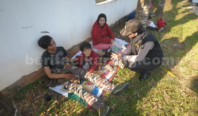 Tim Psikolog Polda Metro Jaya, Brigadir Ni Wayan Mayasari saat menemani Suja dan kedua orangtuanya di lokasi check point Kedungwaringin, Desa Karang Sambung, Kecamatan Kedung Waringin, Sabtu (02/07).